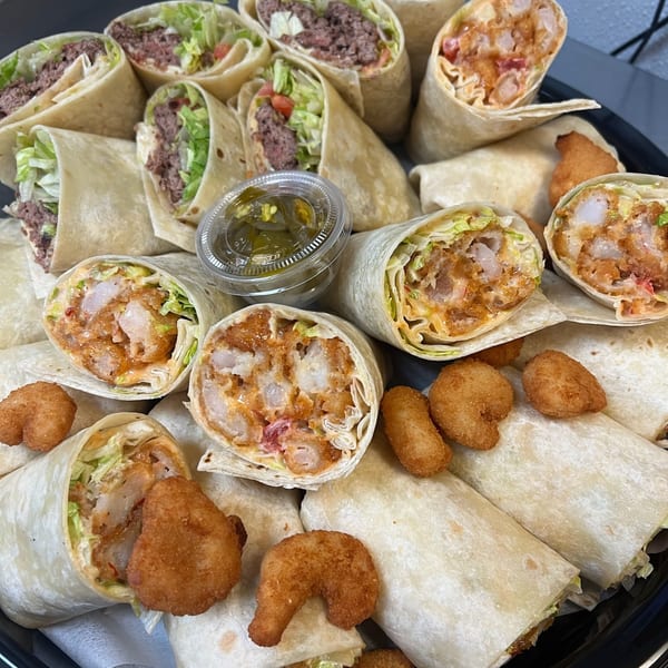 A platter of Burger Shack wraps, some with ground beef and others with fried shrimp, and a side of jalapeños.
